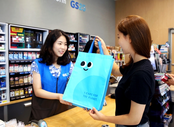 한 소비자가 GS25 편의점 매장에서 친환경 대여쇼핑백을 구매하고 있다. [사진=GS리테일]