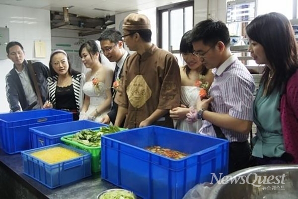타오란쥐의 CEO 옌치가 베이징의 한 매장에서 직원들과 함께 식재료를 살펴보고 있는 광경. [사진=타오란쥐 보도자료]