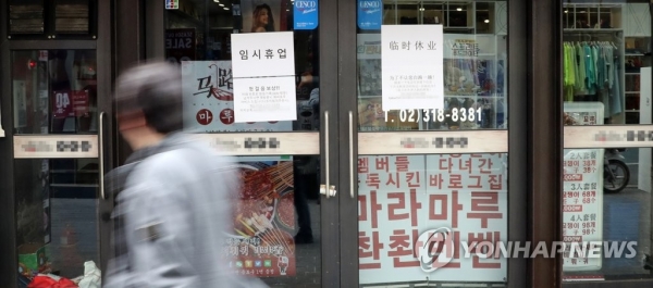 코로나 19 확산으로 인한 소비심리 위축이 현실화하고 있다. 지난 3일 한 시민이 서울 명동에서 임시휴업 안내가 붙은 음식점 앞을 지나고 있다. [사진=연합뉴스]
