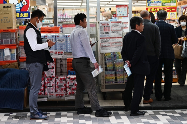 일본 정부의 신종 코로나바이러스 감염증(코로나19) 긴급사태 선포 후에도 감염 확산에 제동이 걸리지 않는 가운데 22일 도쿄의 한 약국에서 마스크를 사려는 사람들이 줄지어 서서 차례를 기다리고 있다. [사진=AFP/연합뉴스]
