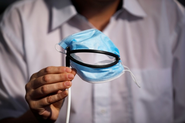 이스라엘 예후다에 있는 압티푸스 특허 발명 연구소(Avtipus Patents and Inventions lab)에서 한 직원이 식사할 때도 벗을 필요가 없도록 기계식 입이 장착 된 마스크를 보여주고 있다. [사진 = 연합뉴스]