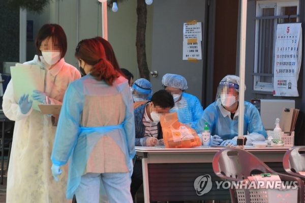 지난 21일 서울 영등포구 보건소 선별진료소에서 의료진이 코로나19 관련 진료를 보고 있다. [사진=연합뉴스]