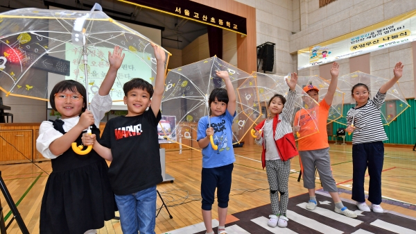 투명우산 나눔 행사에서 학생들이 기념촬영을 하고 있다. [사진=현대모비스]