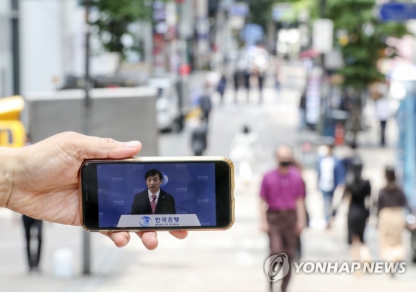 28일 오전 한산한 서울 명동 거리에서 취재진이 스마트폰을 들고 유튜브로 중계되는 '이주열 한국은행 총재의 통화정책방향 기자간담회'를 보고 있다. [사진=연합뉴스]