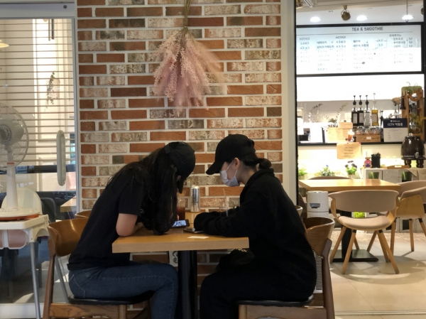 양평물맑은시장 내 한 카페에서 마스크를 쓴 채 대화에 여념 없는 여학생들. [사진 = 뉴스퀘스트]