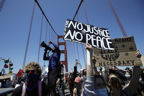 6일(현지시간) 미국 캘리포니아주 샌프란시스코의 금문교 위에서 흑인 남성 조지 플로이드 사망 사건에 항의하는 시위대가 '정의 없이 평화 없다'라고 적힌 손팻말을 들고 행진하고 있다. [사진=AP/연합뉴스]