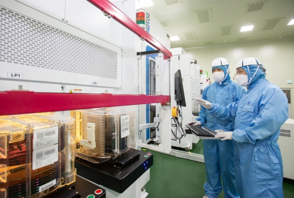 삼성전자 직원(오른쪽)과 협력사 이오테크닉스 직원이 양사가 공동 개발한 반도체 레이저 설비를 함께 살펴보고 있다. [사진=삼성전자 제공]