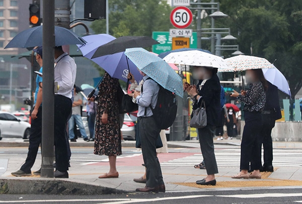 16일 오전 서울 광화문광장 인근에서 시민들이 비를 피해 출근길을 재촉하고 있다. [사진=연합뉴스]