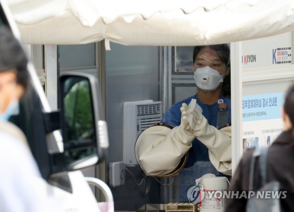 지난 15일 서울 중구 국립중앙의료원 선별진료소에서 의료진이 신종 코로나바이러스 감염증(코로나19) 검체 채취를 마친 뒤 소독을 하고 있다. [사진=연합뉴스]