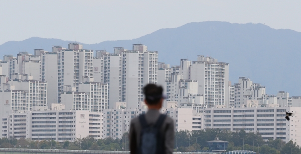 한 시민이 서울 잠실한강공원에서 건너편 아파트 단지를 바라보고 있다. [사진=연합뉴스]