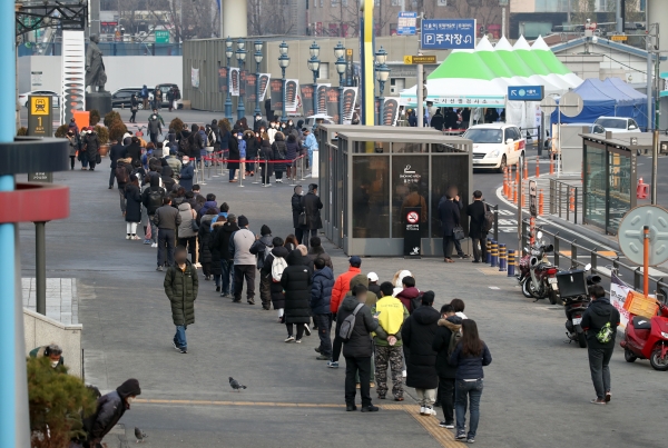 22일 오전부터 시민들이 코로나19 검사를 받기 위해 서울역 광장 임시 선별검사소에 길게 줄을 서 있다. [사진=연합뉴스]