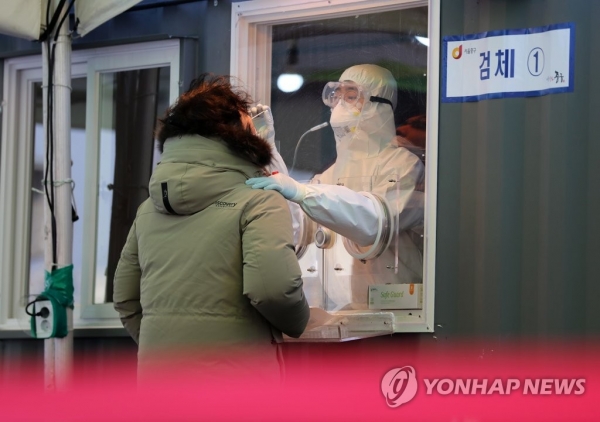 지난 12일 오전 서울역 광장에 마련된 코로나19 임시 선별검사소에서 의료진이 검체채취를 하고 있다. [사진=연합뉴스]