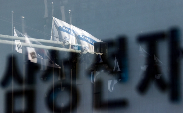 19일 서울 삼성전자 서초사옥의 팻말에 펄럭이는 삼성 깃발의 모습이 반사되고 있다. [사진=연합뉴스]
