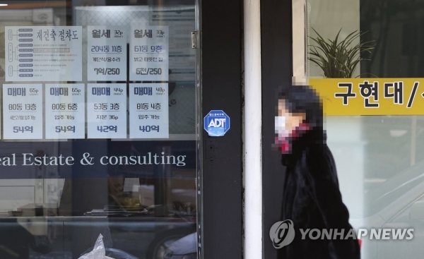 서울의 한 아파트단지 부동산 앞을 한 시민이 지나가고 있다. [사진=연합뉴스]