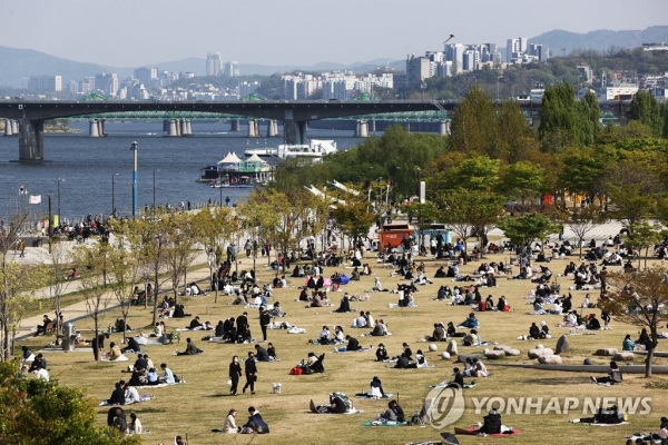 지난 일요일(18일) 오후 여의도 한강공원을 찾은 시민들이 잔디밭에 앉아 봄을 즐기고 있다. [사진=연합뉴스]
