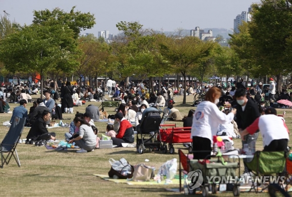 지난 일요일(18일) 오후 여의도 한강공원을 찾은 시민들이 잔디밭에 앉아 봄을 즐기고 있다. [사진=연합뉴스]