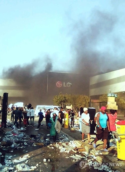 남아프리카공화국 더반에 있는 LG전자 공장이 불에 타는 등 우리 기업도 큰 피해를 봤다. 12일 시위 군중에 의해 불타고 약탈당하는 더반 LG전자 공장을 교민이 촬영했다. [연합뉴스]