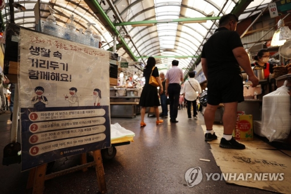 코로나19 확산세가 이어지고 있는 가운데 13일 오후 서울 종로구의 한 전통시장에 방역 관련 안내문이 붙어 있다. [사진=연합뉴스]