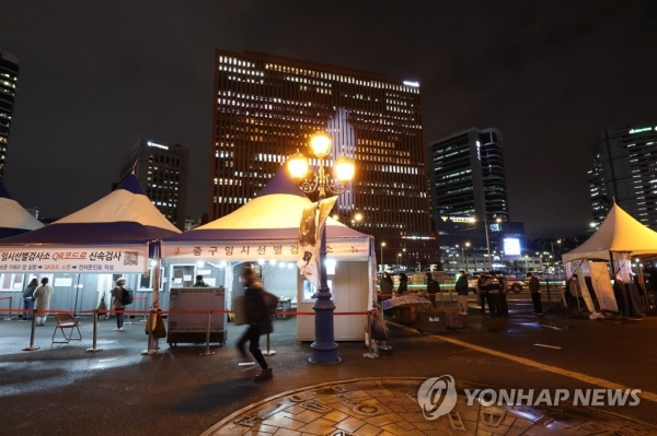 지난달 30일 밤 서울역 광장에 마련된 중구 임시선별검사소에 퇴근 시간 이후에도 시민들이 줄을 서서 검사 순서를 기다리고 있다. [사진=연합뉴스]