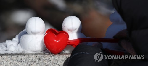 19일 오전 서울 북악 팔각정에서 한 어린이가 눈사람, 눈오리 등을 만들고 있다. [연합뉴스]