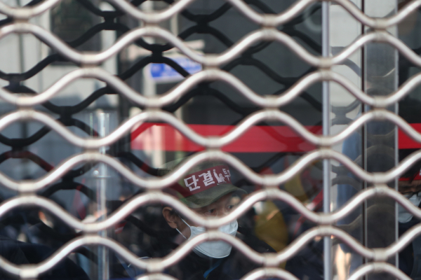 지난 11일 서울 중구 CJ대한통운 본사에서 CJ대한통운 택배노조 조합원이 머리띠를 한 채 앉아 있다. 앞서 택배노조는 10일 오전 11시 30분께 CJ대한통운 본사를 기습 점거하고 농성에 돌입했다. [연합뉴스]