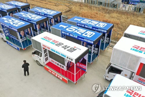 20대 대선 공식선거운동 개시일을 이틀 앞둔 13일 광주 광산구에 위치한 차량광고업체에 후보들의 선거 유세 차량이 놓여있다. [연합뉴스]