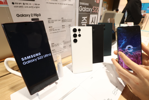 22일 서울 종로구 KT플라자 광화문역점을 찾은 시민이 삼성전자의 플래그십 스마트폰 갤럭시 S22를 체험하고 있다. [연합뉴스]