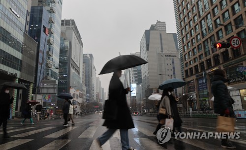이번 주말 전국에 비예보가 있다. 서울 마포구 홍대 거리에서 우산을 쓴 시민이 길을 건너고 있다. [연합뉴스]