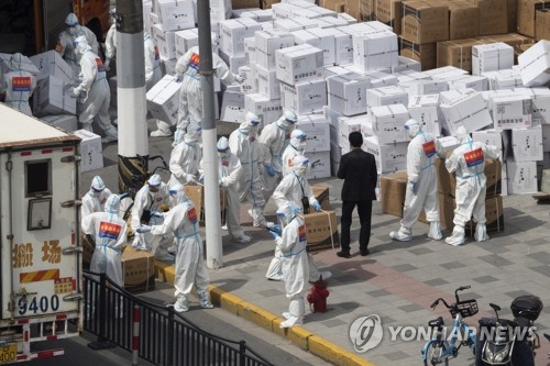 10일 코로나19 확산을 막기 위한 봉쇄 상태가 지속되고 있는 중국 상하이에서 작업자들이 마스크가 든 상자 등 방역물자를 하역하고 있다. [AP=연합뉴스]