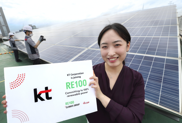 KT 직원이 관악구 KT구로타워 옥상에 구축된 태양광발전소에서 'RE100 가입'을 알리고 있다. [사진=KT]