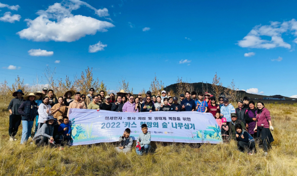 몽골 북동부 에르덴솜 지역에서 나무심기 봉사활동을 마치고 단체사진을 찍고 있는 몽골 학생 봉사단. [사진=오비맥주]