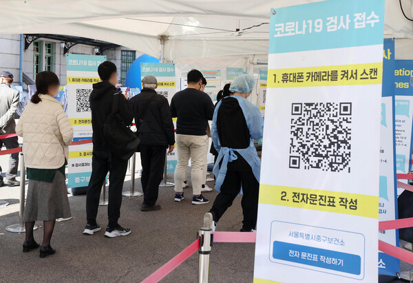 25일 오후 서울역 코로나19 임시선별검사소에서 시민들이 검사를 받기 위해 줄을 서 있다. [연합뉴스]