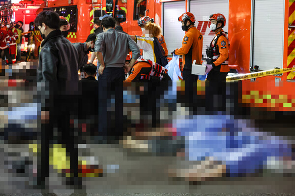 서울 용산구 이태원에서 할로윈 행사를 즐기러 온 인파가 몰리면서 대규모 인명사고가 발생했다. 30일 오전 출동한 119 구조대원들이 희생자들을 분류하는 모습. [사진=연합뉴스]