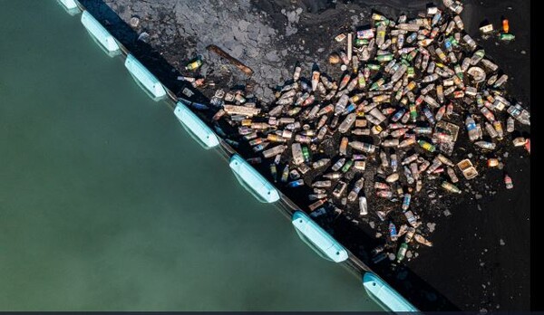 자마이카 킹스턴 항구의 반스 수로에 설치된 인터셉터 시스템에 의해 차단된 플라스틱 쓰레기[사진=오션 클린업]