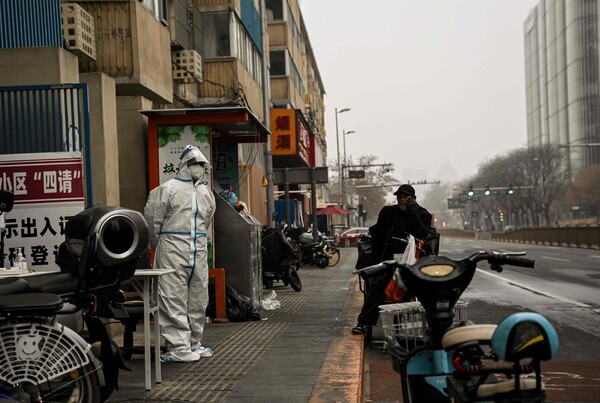 최근 코로나19 감염자 급증으로 중국 베이징에서 봉쇄조치가 시행되는 가운데 한 보건당국 직원이 24일(현지시간) 봉쇄된 한 주택지구 입구를 지키고 있다. [AFP=연합뉴스]