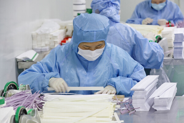 중국에서 코로나19 감염자가 폭증하는 가운데 장쑤성 난퉁의 한 공장에서 직원이 코로나19 신속항원검사 키트를 만들고 있다. [AFP=연합뉴스]