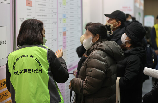 올해 기초연금 수습 기준이 지난해에 비해 높아졌다. 서울 마포구청에서 열린 노인 일자리 박람회에서 봉사자로부터 설명을 듣고 있는 노인들. [연합뉴스]