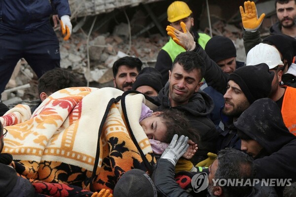 튀르키예 지진으로 붕괴된 건물 잔해에서 구조된 소녀가 들것으로 옮겨지고 있다. [로이터=연합뉴스]
