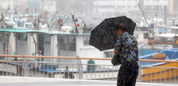 10일 오전 경남 통영시 강구안 주변에서 우산을 쓴 시민이 걸어가고 있다. 통영지역은 제6호 태풍 '카눈'의 상륙 길목으로 예보된 곳이다. [연합뉴스]