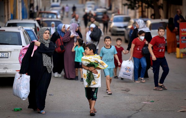팔레스타인 여성들과 어린이들이 13일(현지시간) 가자지구 중심 도시 가자시티에서 짐을 챙겨 피신하고 있다. 이스라엘은 팔레스타인 무장 정파 하마스와의 무력 충돌 이레째인 이날 가자시티 주민 전원에게 대피령을 내렸다. [로이터=연합뉴스]