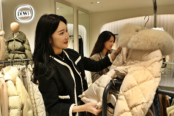 여성 고객이 롯데백화점 의류 매장에서 겨울 상품을 둘러 보고 있다. [사진=롯데쇼핑]