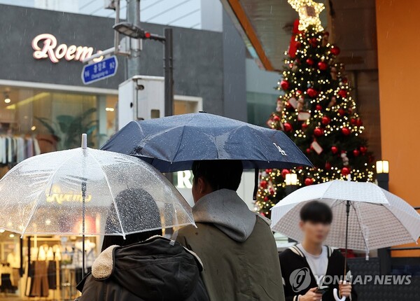 지난 14일 오후 광주 동구 충장로에서 시민들이 내리는 겨울비에 우산을 쓰고 걷고 있다. [사진=연합뉴스]