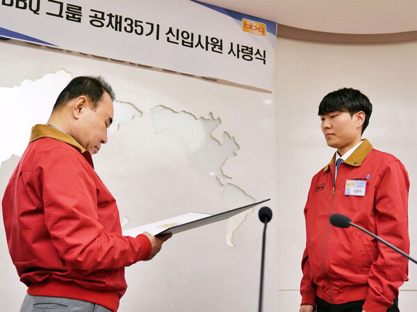 제너시스BBQ 그룹 윤홍근 회장(왼쪽)이 2023 하반기 공개채용 신입사원에게 사령장을 수여하고 있다. [제너시스비비큐]
