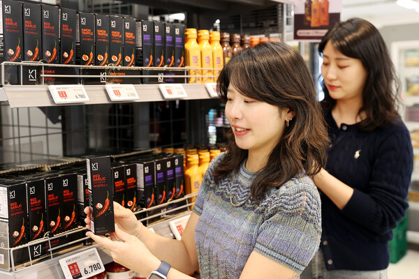 교촌에프앤비 직원들이 이마트에 진열된 'K1 소스' 상품을 살펴보고 있다. [사진=교촌에프앤비]