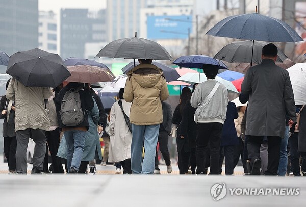 서울 광화문광장에서 시민들이 우산을 쓴 채 걸어가고 있다. [사진=연합뉴스]