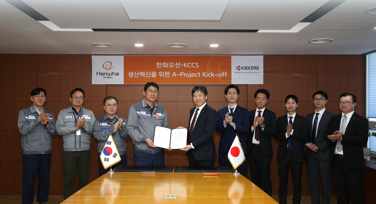 한화오션 조선소장 이길섭 부사장(왼쪽에서 네번째)이 교세라社의 마츠나가 카즈히로 사업부장(왼쪽에서 다섯번째)과 계약서에 서명하고 기념 촬영하고 있다. [한화오션 제공=뉴스퀘스트]