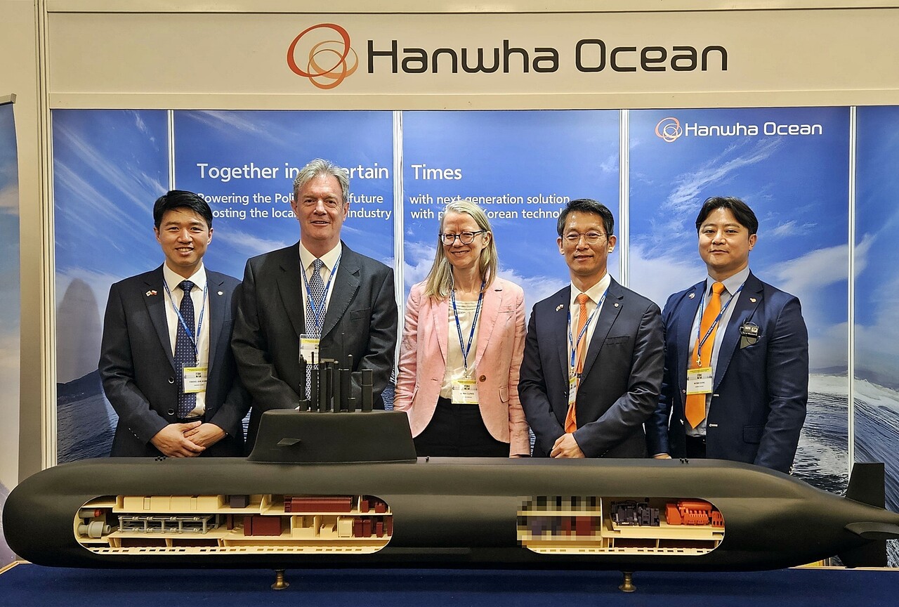 영국 밥콕 인터내셔널 국제 부문 총괄 닉 하인 경(왼쪽에서 두번째) , 폴란드 주재 영국 대사 안나 클룬즈(왼쪽에서 세번째)와 한화오션 정승균 특수선 해외사업단장(오른쪽에서 두번째) 등 관계자들이 지난 20일 폴란드 바르샤바에서 열린 국제 해양 안보 포럼에 참가, 한화오션이 별도 마련한 전시 부스를 방문해 기념촬영을 하고 있다. [한화오션 제공=뉴스퀘스트]