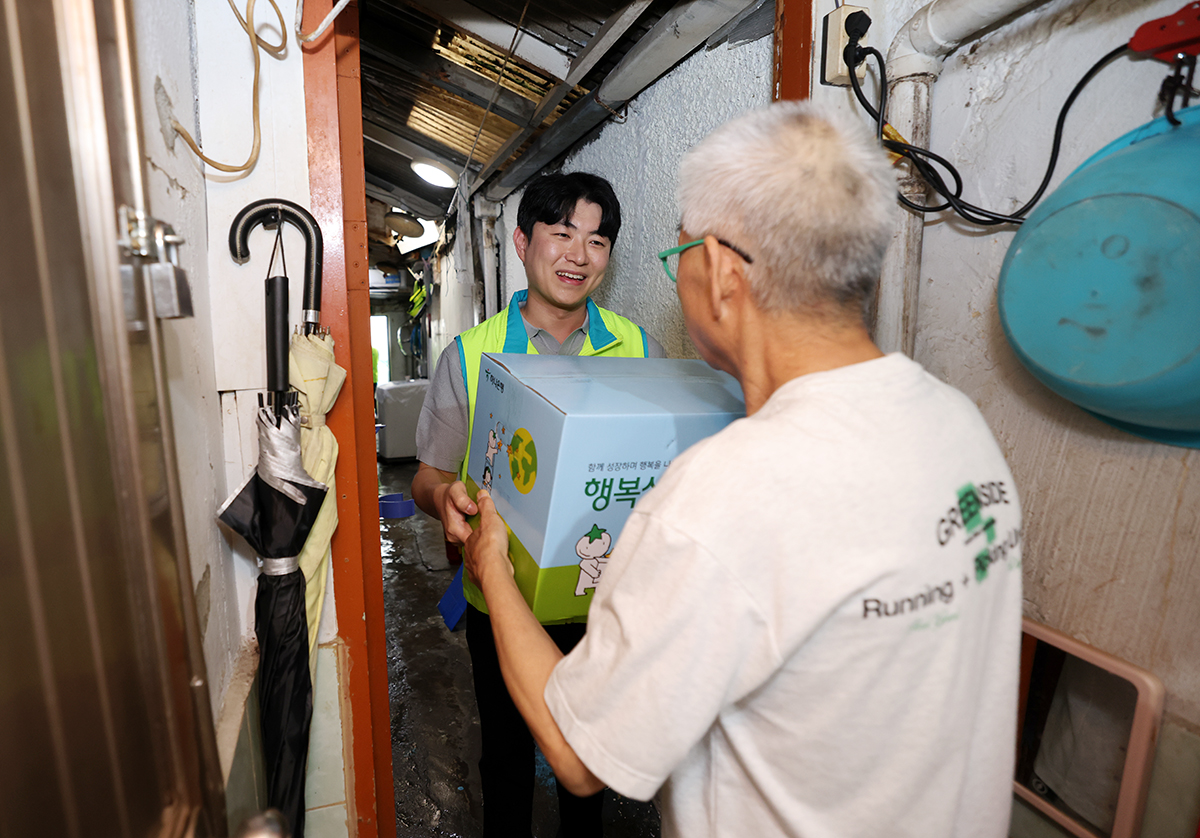 하나금융그룹은 지난 17일 여름철 무더위로 고통받는 지역사회 취약계층을 위해 여름용품이 담긴 행복상자 1111개를 전달했다고 18일 밝혔다. 하나금융그룹 직원이 영등포역 인근 쪽방촌에 찾아가 독거 어르신에게 행복상자를 전달하는 모습. [하나금융그룹 제공=뉴스퀘스트]
