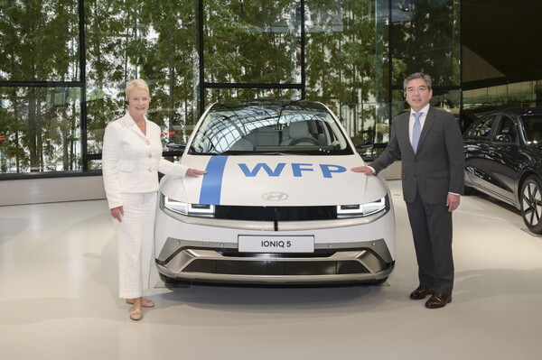 현대자동차가 유엔세계식량계획과 모빌리티 부문 파트너십을 체결했다. 현대차는 이번 협약을 통해 친환경 모빌리티 전환을 돕고 유엔지속가능발전목표 달성을 지원할 계획이다. (사진 오른쪽부터) 장재훈 현대차 사장 과 신디 매케인 WFP 사무총장이 WFP 로고로 랩핑한 아이오닉 5 옆에서 기념사진을 찍고 있는 모습 [현대자동차 제공=뉴스퀘스트]