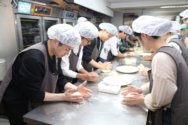 ‘사랑의 빵 만들기’ 봉사활동에 참여한 DL이앤씨 직원들이 밀가루를 반죽하고 있다. [DL이앤씨 제공=뉴스퀘스트]